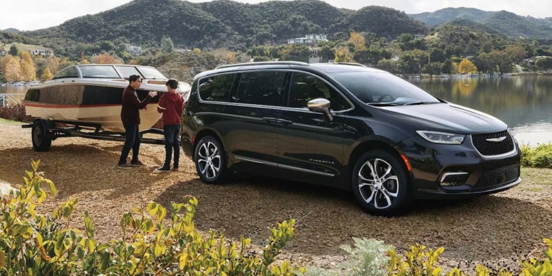 A Chrysler Pacifica parked beside a boat, showcasing its spacious design and versatility for family outings.